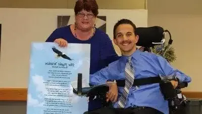 Garrett Putnam with Mary Westgate, Polk State's disability services coordinator. Westgate presented Putnam with a laminated version of his poem, "的 Fight Within," during last month's Criminal Justice Teach-In.